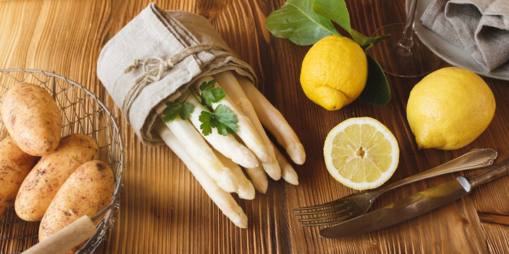 seasonal fresh white asparagus. spring vegetables with ingredients for a menu on wood. sunny kitchen