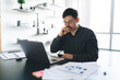 © BullRun - Pensive young man working on laptop in living room