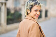 © ADDICTIVE STOCK - Cheerful woman in stylish outfit walking on pavement