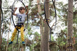 © Katia - Child in yellow pants climbing in a rope park