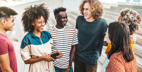 Wall Mural - Multicultural friends having fun outside - University students standing in college campus - Youth community concept with guys and girls talking and laughing together