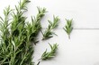 © Nadia - a branch of rosemary on a white wooden background with a place for text or a picture to put on a greeting card or a gift card.  generative ai