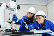 © gumpapa - female automation machine engineer student study and inspection control robot arm machine in university or factory workshop. ai robot technology new innovation trend of manufacturing in industry 5.0