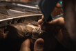 Close up of a goldsmith's hand making a gold or silver ring or a diamond using goldsmith's tools. Making ring with diamonds