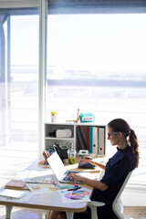 Canvas Print - Female executive workingBusinesswoman working over laptop and graphic tablet at desk over laptop and