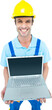 © vectorfusionart - Happy repairman wearing hard hat while holding laptop