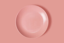 Pink plate on a pink background. View from above. Concept
