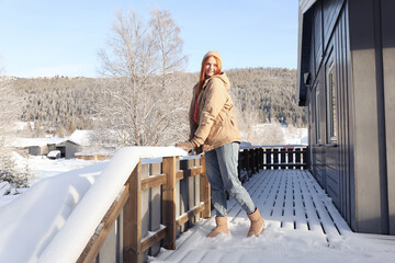 Wall Mural - Happy young woman on terrace outdoors. Winter vacation