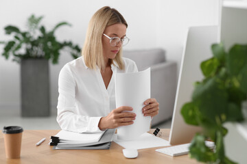 Wall Mural - Woman working with documents at wooden table in office