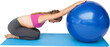 Side view of a fit young woman exercising with fitness ball