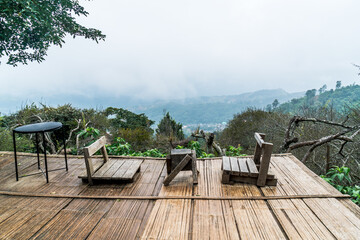 Wall Mural - chair on balcony with mountain hill and foggy background