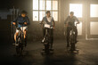 © Videophilia - A group of three young sportsmen exercising and riding stationary bike at gym