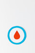 Blood drop in blue ring on white background with copy space