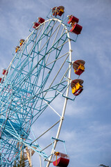  Ferris wheel, booths against the blue sky.