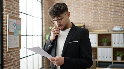 Poster - Young arab man business worker reading document at office