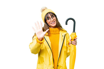 Canvas Print - Young caucasian woman with rainproof coat and umbrella over isolated chroma key background counting five with fingers