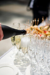 Poster - Stylish champagne glasses and food appetizers on table at wedding reception