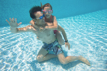 Sticker - underwater photo of young dad with little girl in swimming  pool