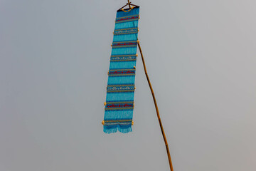 handmade traditional blue lanna tung hanging on the bamboo pole in thai temple, tung is a symbol of 