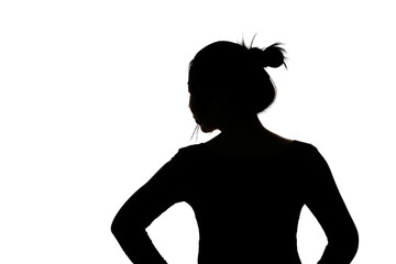 Black backlit silhouette of head and shoulders of an oriental woman from back view outlined by light