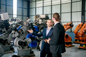 Wall Mural - Businessman pointing toward machinery while walking by coworker at industry