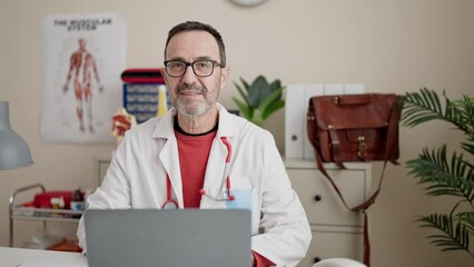 Wall Mural - Middle age man doctor using laptop working at clinic