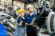 © FotoArtist - Engineer with robot in automotive parts factory