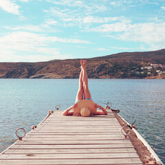 Wall Mural - legs of woman on wooden pier- relax,  happy,  vacation concept