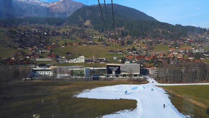 Wall Mural - Ski chair lift with a view of the summit and the slopes. Beautiful ski resort after snowfall with blue sky and bright sun. Ski cabins transporting skiers and snowboarders. 