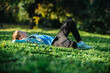 © Valua Vitaly - Young cheerful child relaxing in a park. Smiling child laying down on the grass in a garden and dreaming, on a sunny summer day. Happy young boy imagining his future on a warm summer day.