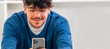 © carballo - young male student looking at mobile phone smiling
