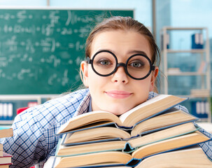 Wall Mural - Female student with many books sitting in the classroom