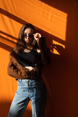 Wall Mural - fashionable woman in jeans in sunset light in the room