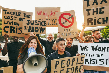 Wall Mural - Crowd of multiracial people protest against inflation and financial crisis - Protesters marching for rise cost of living - Focus on woman with megaphone