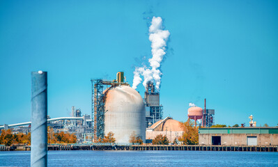 Wall Mural - Industrial facility. Exterior of modern petrochemical plant with reactors and converters. Smoke from the chimney.