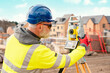 © Iryna - Surveyor builder site engineer with theodolite total station at construction site outdoors during surveying work