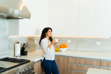 Relaxed woman enjoying coffee in the luxury kitchen