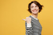 © ViDi Studio - Sideways young woman in casual striped black and white shirt point index finger aside indicate on workspace area copy space mock up isolated on plain yellow color background studio Lifestyle concept
