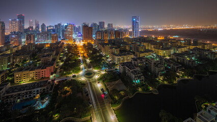 Wall Mural - Skyscrapers in Barsha Heights district and low rise buildings in Greens district aerial all night timelapse.