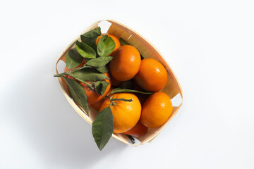 Sticker - Fresh mandarin in a wooden package on a white background. Top view, flat lay