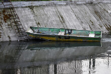 Old Wooden Boat In The City River. Old Style Grunge Boat. Old Fishing Rowboat.