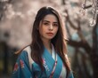 © drixe - Beautiful asian woman with long and straight hair wearing a colorful kimono, looking serious, standing in a background of cherry blossom trees. created with Generative AI