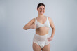 Woman in adult diapers smiling and showing thumbs up. Urinary incontinence problem. 