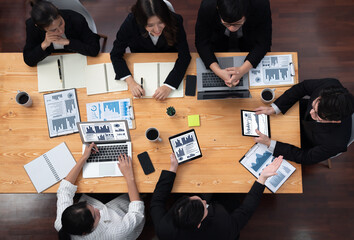 Top-view business team of financial data analysis meeting with business intelligence, report paper and dashboard on laptop for marketing strategy. Business people working together in office of harmony