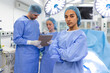 © Graphicroyalty - Portrait of female woman nurse surgeon OR staff member dressed in surgical scrubs gown mask and hair net in hospital operating room theater making eye contact smiling pleased happy looking at camera