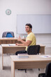 © Elnur - Young male student teacher sitting in the classroom
