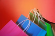 Colorful paper shopping bags on an orange background