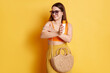 Portrait of smiling attractive woman applying sunblock on her arm, using sunscreen for skin protect during hot summer days, posing isolated over yellow background.