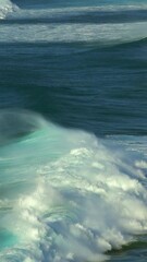 Wall Mural - Large foamy waves rolling on the surface of a stormy ocean. Vertical video