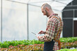 © Prathankarnpap - Image of smart farmer using digital tablet monitor quality organic vegetable in greenhouse before harvest